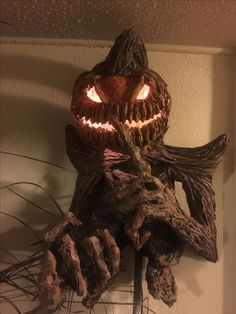 a carved pumpkin hanging from the side of a wall