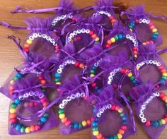 purple bags filled with lots of candy on top of a wooden table