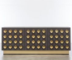 the sideboard is made out of metal and has gold studs on it