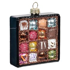 an ornament with many different types of candies in the box on white background