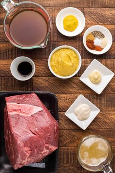 raw meat, spices and seasonings on a wooden table with ingredients to make it