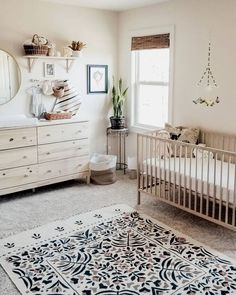 a baby's room with a crib, dresser and rug on the floor