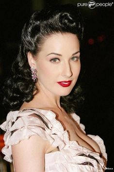 a woman with dark hair wearing a white dress and red lipstick is posing for the camera