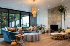 a living room filled with furniture and a fire place in front of a large window