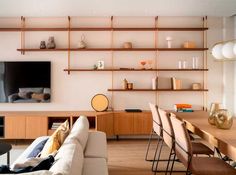 a living room filled with furniture and a flat screen tv mounted on a wall above a fireplace