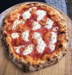 a pizza sitting on top of a wooden cutting board