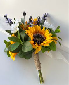 a bouquet of sunflowers and other flowers on a white surface