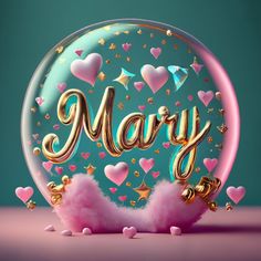 a snow globe with the word mary written in gold letters and pink fluffy balls surrounding it