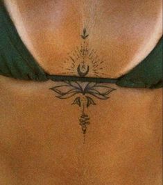 a woman's stomach with a tattoo design on the side and an arrow in the middle