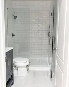 a white toilet sitting next to a walk in shower