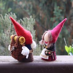 two small gnomes are sitting on a ledge