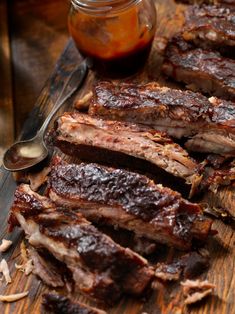 barbecue ribs on a cutting board with bbq sauce