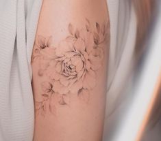 a woman's arm with a flower tattoo on the left side of her arm