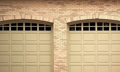 two brown garage doors are open in front of a brick wall