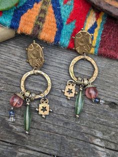 "Vintage Southwestern Style Earrings  *Most likely made in the 80's. *Gold tone metal earrings stamped with suns and stars *Pink & green glass dangles *Pierced posts *They measure 3\" tall and 1\" wide *In good vintage condition, only minor signs of wear appropriate to their age including light scratches and wear to metal finish" Vintage Dangle Beaded Earrings For Festival, Bohemian Brass Drop Clip-on Earrings, Vintage Green Earrings For Festival, Vintage Green Festival Earrings, Bohemian Brass Clip-on Earrings Nickel Free, Bohemian Metal Clip-on Earrings, Pink Bohemian Nickel-free Chandelier Earrings, Bohemian Green Earrings With Dangling Charms, Green Bohemian Earrings With Dangling Charms