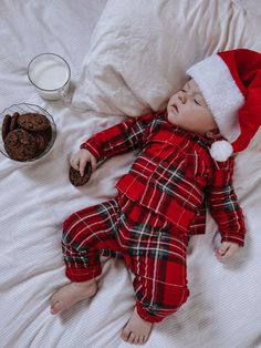 a baby doll laying on top of a bed wearing a santa hat