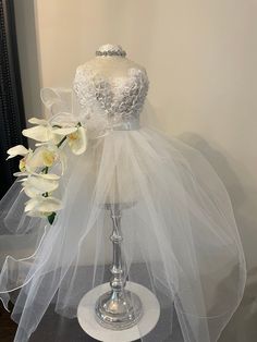 a mannequin with white tulle and flowers on it