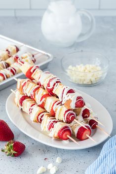 strawberries and marshmallows are on skewers with toothpicks