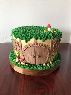 a cake that looks like a hobbot house with trees and mushrooms on it