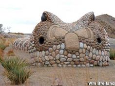 there is a large rock sculpture made out of rocks and stones in the shape of an animal's head