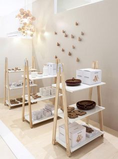 an assortment of desserts on display in a bakery shop with wooden shelves and white walls