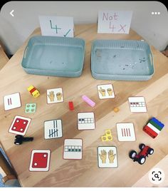 two plastic trays filled with magnets on top of a wooden table