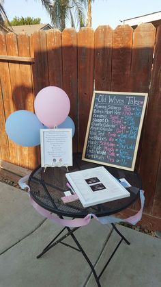 a table that has some balloons on it and a chalkboard in the back ground