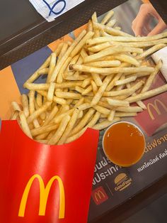 french fries and ketchup sit on a table next to a mcdonald's napkin