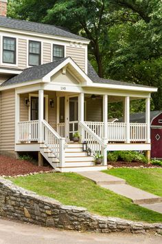 a small house with two porches and steps leading up to the front door is shown