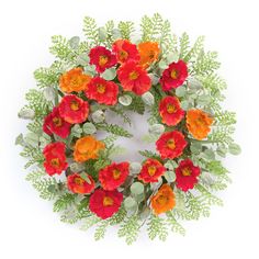 an overhead view of a wreath with red and orange flowers