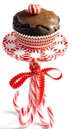 a chocolate cake sitting on top of a red and white plate with candy canes