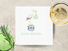 a stork baby shower napkin next to a glass of beer