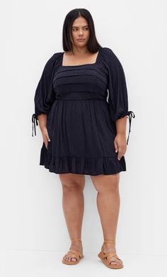 Indulge in the chic styling of our Allegra Mini Dress. The frilled hem brings charm to your look. Along with an all over dobby spot shirred fabrication and a shirred back waist, this piece is an effortless style to complete your collection. Key Features Include: - Square neckline - Tiered bodice - Shirred back waist - Elbow sleeves with elastic cuff - Pull over style - Mini length - Frilled hemline - All over dobby spot shirred fabrication Team with a statement purse for a bold touch. | Plus Siz Black Dress With Cowboy Boots, Dress With Cowboy Boots, Plus Size Black Dress, Statement Purse, Dresses With Cowboy Boots, Plus Size Black Dresses, Dresses Date Night, Plus Size Black, Date Night Dresses