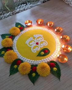 a decorated diya with candles and flowers on the floor