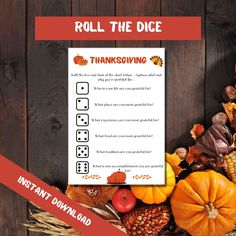 a thanksgiving roll the dice game with pumpkins, corn and other autumn decorations on it