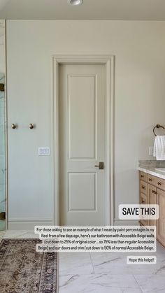 a white bathroom with marble counter tops and wooden cabinetry, along with an ornate rug on the floor