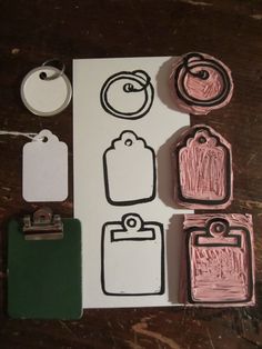 some pink and green rubber stamps are on a piece of paper next to other items