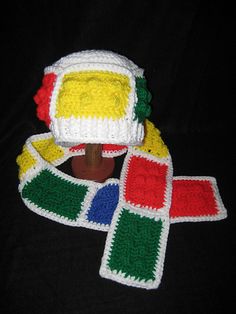 a crocheted hat and scarf on a black surface