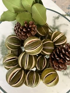 there are some pine cones and nuts on the glass plate