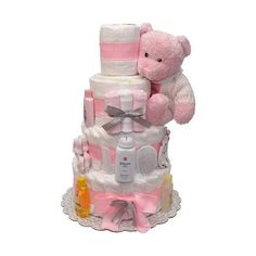 a pink teddy bear sitting on top of a baby diaper cake