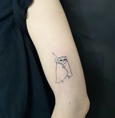 a woman's arm with a small black and white cat tattoo on the left forearm