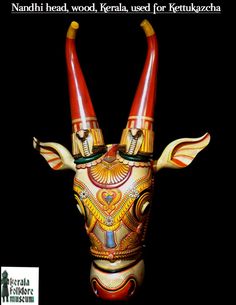 an animal head with two horns painted on it's face and the words nandi head, wood, kerala, used for keruzachura