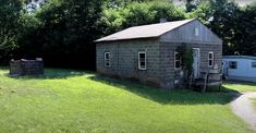 an old brick house sitting on top of a lush green field