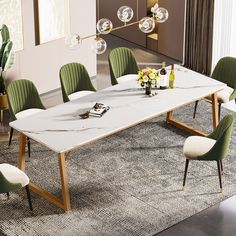 a dining room table with green chairs and a white marble top, in front of a large window