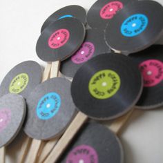 a bunch of different colored discs sitting on top of wooden sticks