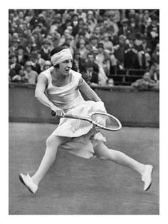 an old photo of a woman playing tennis in front of a crowd with people watching