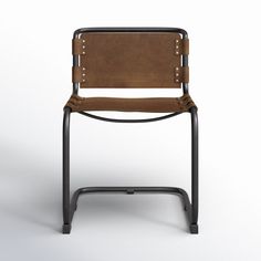 a brown leather chair sitting on top of a black metal frame with rivets