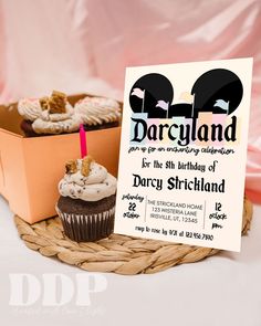 two cupcakes and a birthday card on a basket