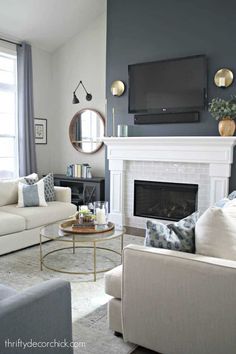 a living room filled with furniture and a flat screen tv mounted on the wall above a fireplace