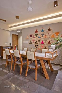 the dining room table is surrounded by wooden chairs and modern art work on the wall